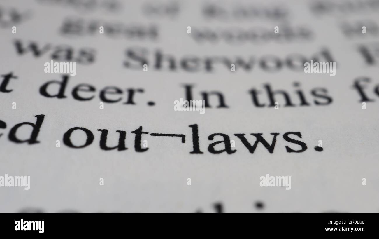Out-laws Text auf offener Buchseite, selektiver Fokus, Nahaufnahme, Makroaufnahme der englischen Botschaft, Bildungsidee und neuartiges Konzept, Sitzansicht Stockfoto