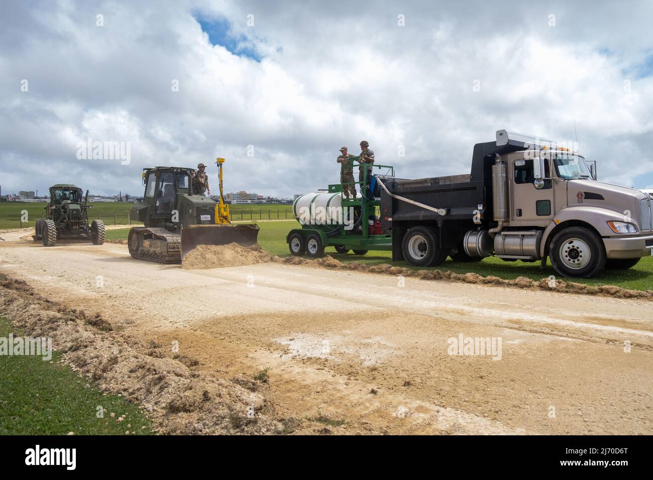 Flieger der 18. Civil Engineer Squadron und Marines der Marine Wing Support Squadron 172 betreiben einen Hydroseeder, D6K Angle-Blade Dozer und 120m Road Grader im Camp Futenma, Japan, 26. April 2022. Der Wasserschlauch des Hydroseeder wurde zur Befeuchtung des exzessoren Schmutzes verwendet, während der D6K Angle-Blade Dozer den Schmutz entfernte und der 120m Road Grader sicherstellte, dass die Oberfläche flach war. (USA Luftwaffe Foto von Airman 1. Klasse Sebastian Romawac) Stockfoto
