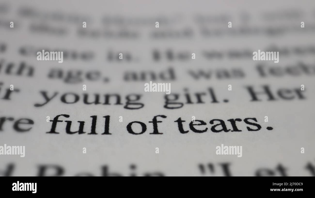 Voller Tränen Text auf offener Buchseite, selektiver Fokus, Nahaufnahme, Makroaufnahme der englischen Botschaft, Bildungsidee und neuartiges Konzept, Sitzansicht Stockfoto
