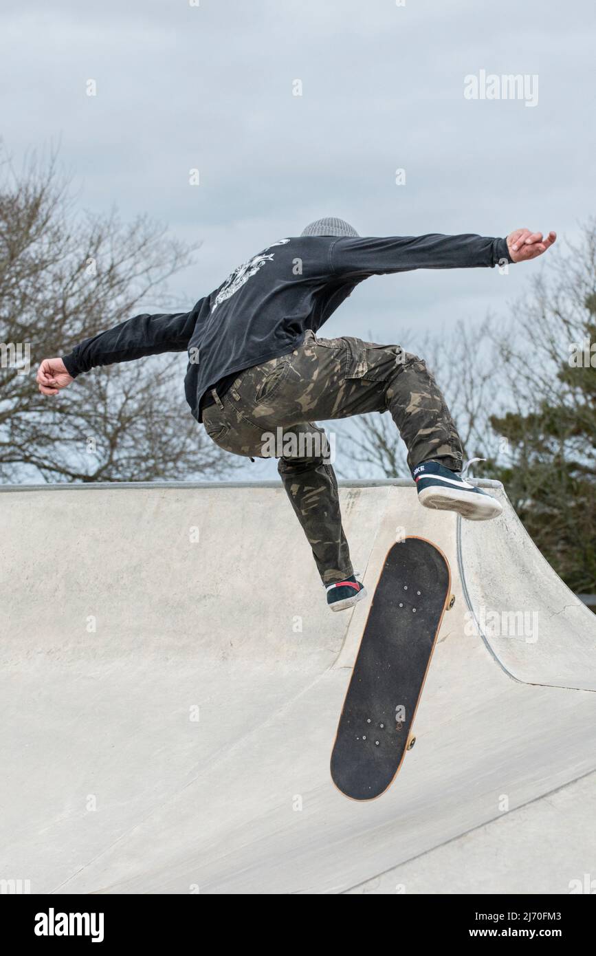Ein reifer männlicher Skateboarder, der einen Trick im Newquay Concrete Waves Skatepark in Newquay in Cornwall in Großbritannien macht. Stockfoto