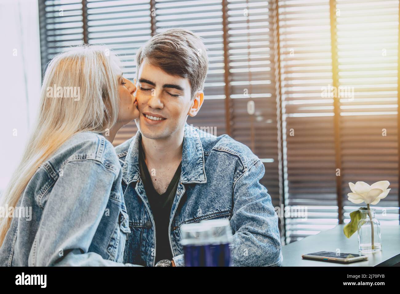 Junges Paar Liebhaber küssen zusammen, Wange küssen Liebeausdruck im öffentlichen Raum. Stockfoto