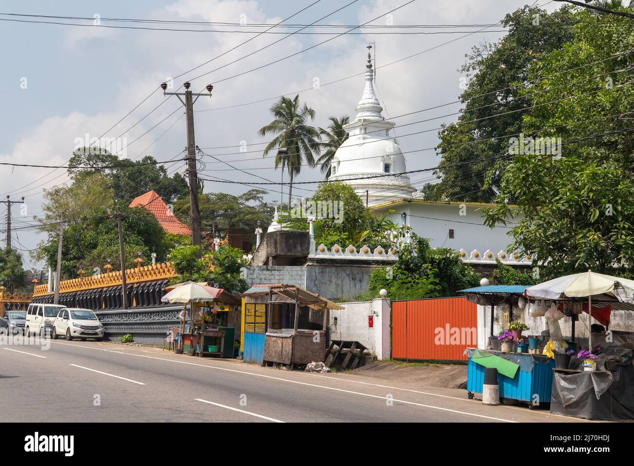Malabe, Sri Lanka - 4. Dezember 2021: Malabische Straßenansicht mit der Kuppel des Sri Sudharshanarama Purana Viharaya auf einem Hintergrund, Haupttempel für Bu Stockfoto