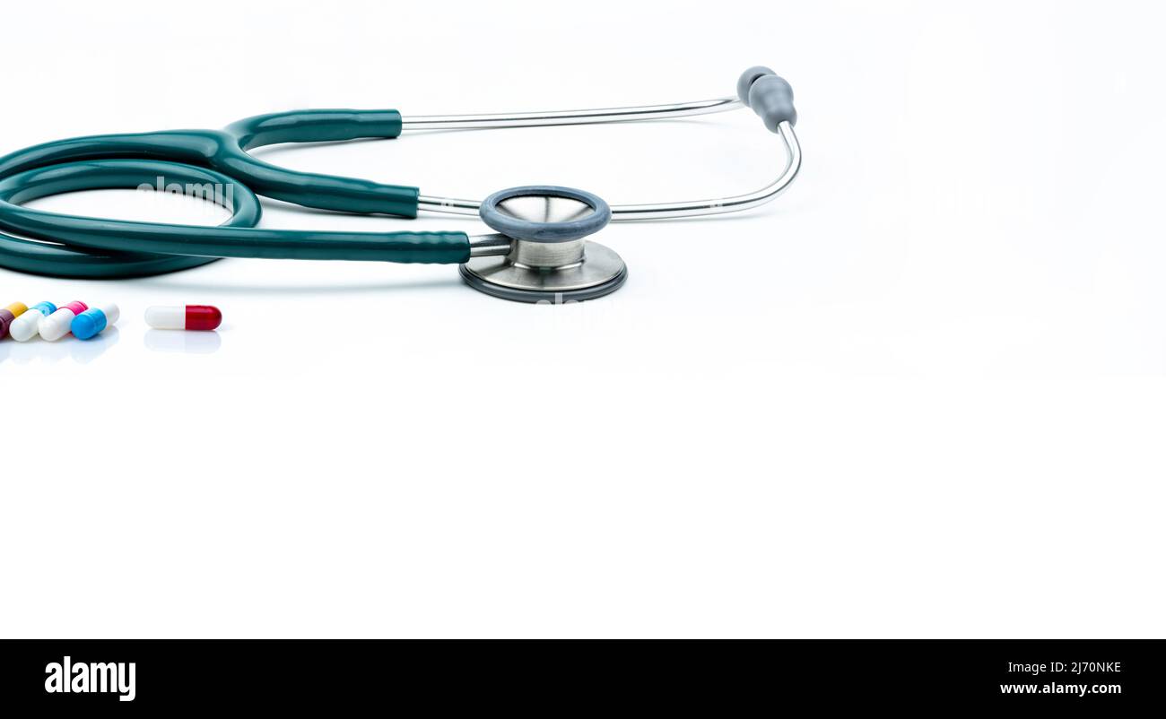 Grüne Stethoskop- und Kapselpillen auf weißem Hintergrund. Health Check. Kardiologische Ausrüstung für den Herzschlagtest. Gesundheitswesen und Medizin. Stockfoto