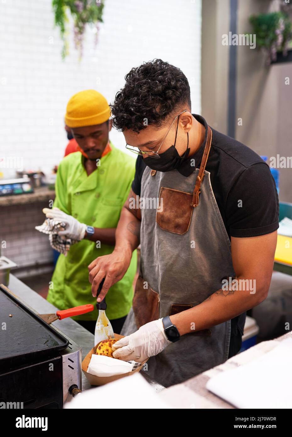 Ein Koch und sein Assistent bereiten Tacos an einem Imbissstand zu Stockfoto