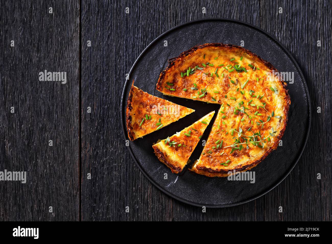 Geschnittener Speck und Cheddar-Quiche mit zerfetzter Kartoffelkruste ...