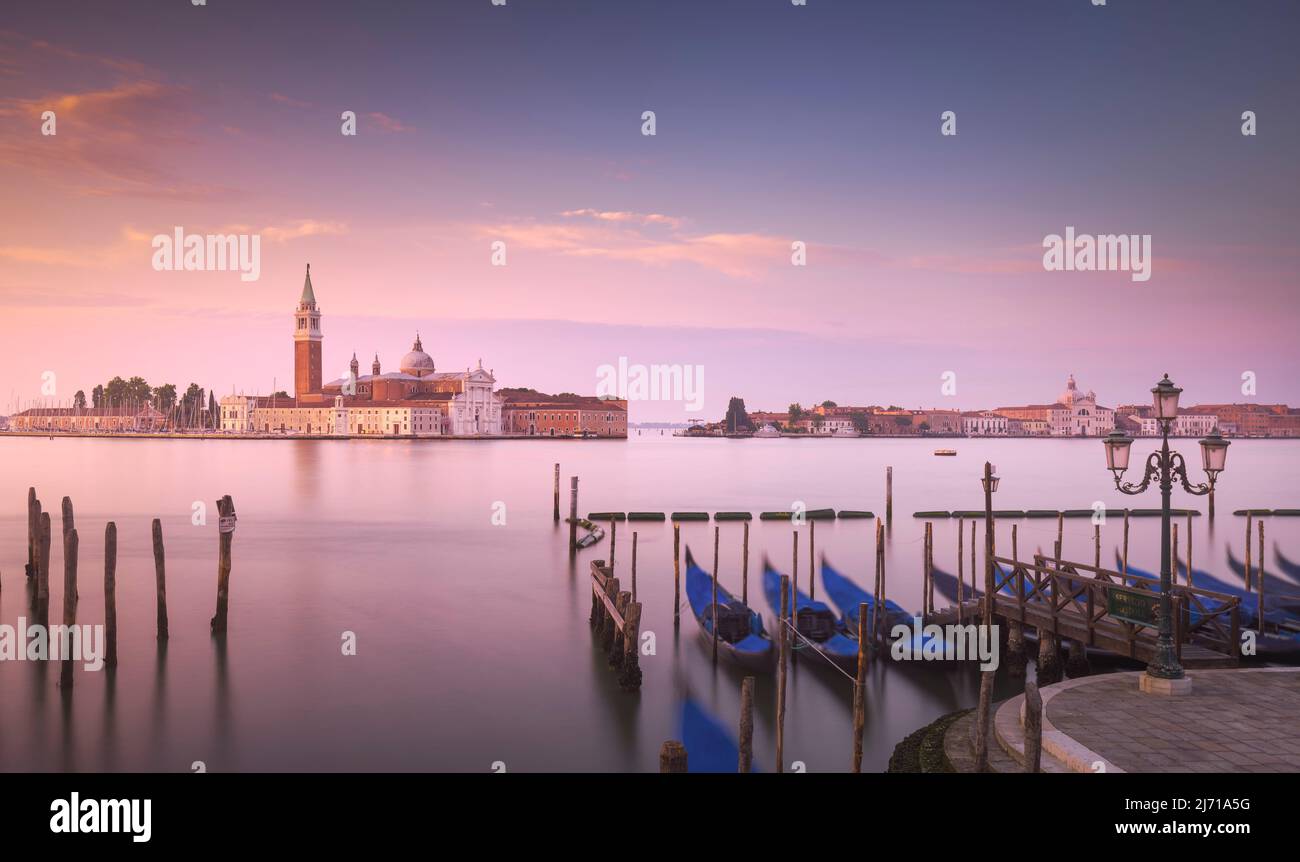 Lagune von Venedig bei Sonnenaufgang, Kirche San Giorgio Maggiore und Gondeln. Italien, Europa. Langzeitfotografie. Stockfoto