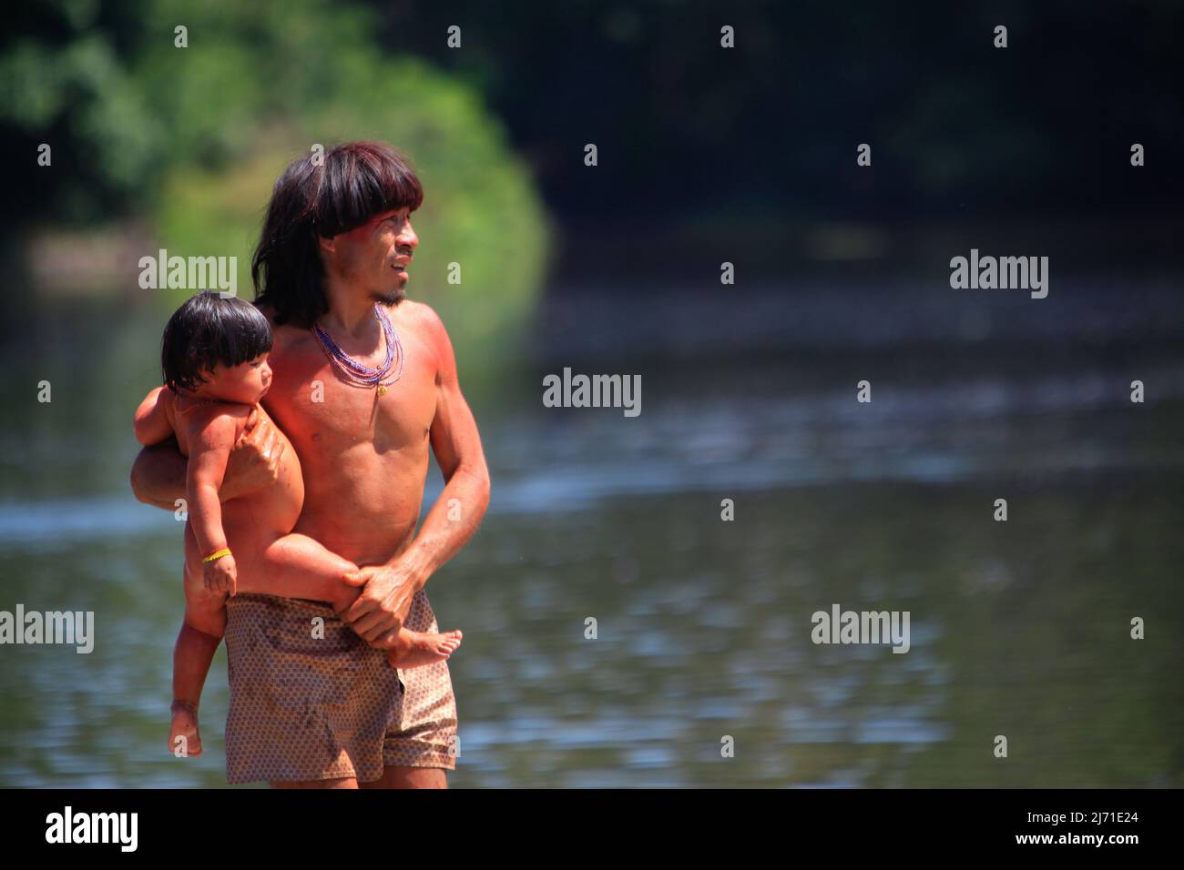 Indischer Vater trägt Stammes-Körperfarbe, die Baby am Amazonas in Brasilien hält, 2010. Stockfoto