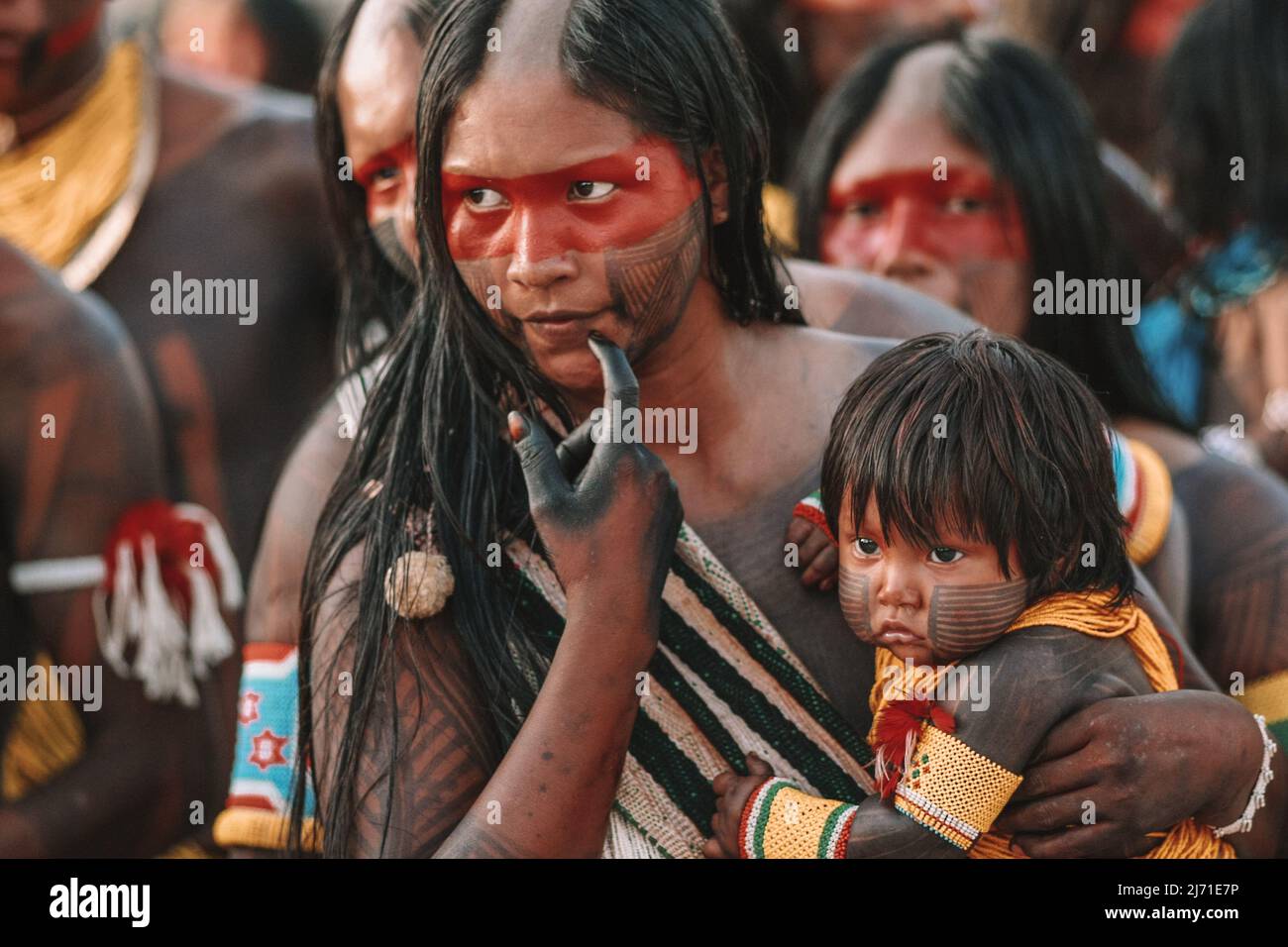 Indigene Frau mit halbrasiertem Kopf, aus einem Amazonas-Stamm in Brasilien, mit Baby, beide mit Stammesanstrich. Jogos Indígenas, Xingu River, 2009. Stockfoto