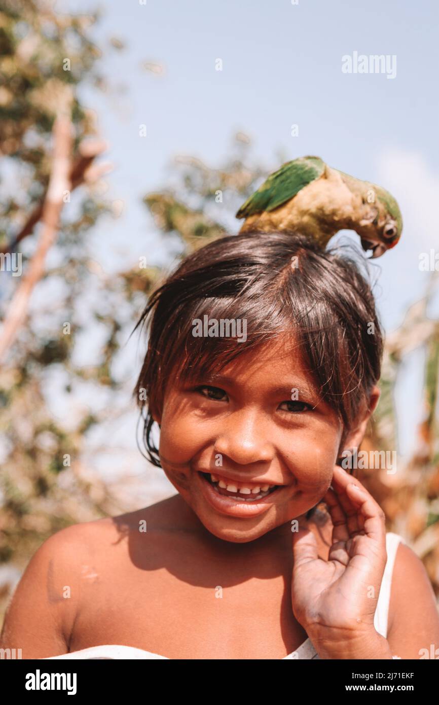 Brasilianisches Amazon indisches Mädchen lächelt und spielt mit Vogel. Xingu River, Amazonas, Brasilien. 2010. Stockfoto