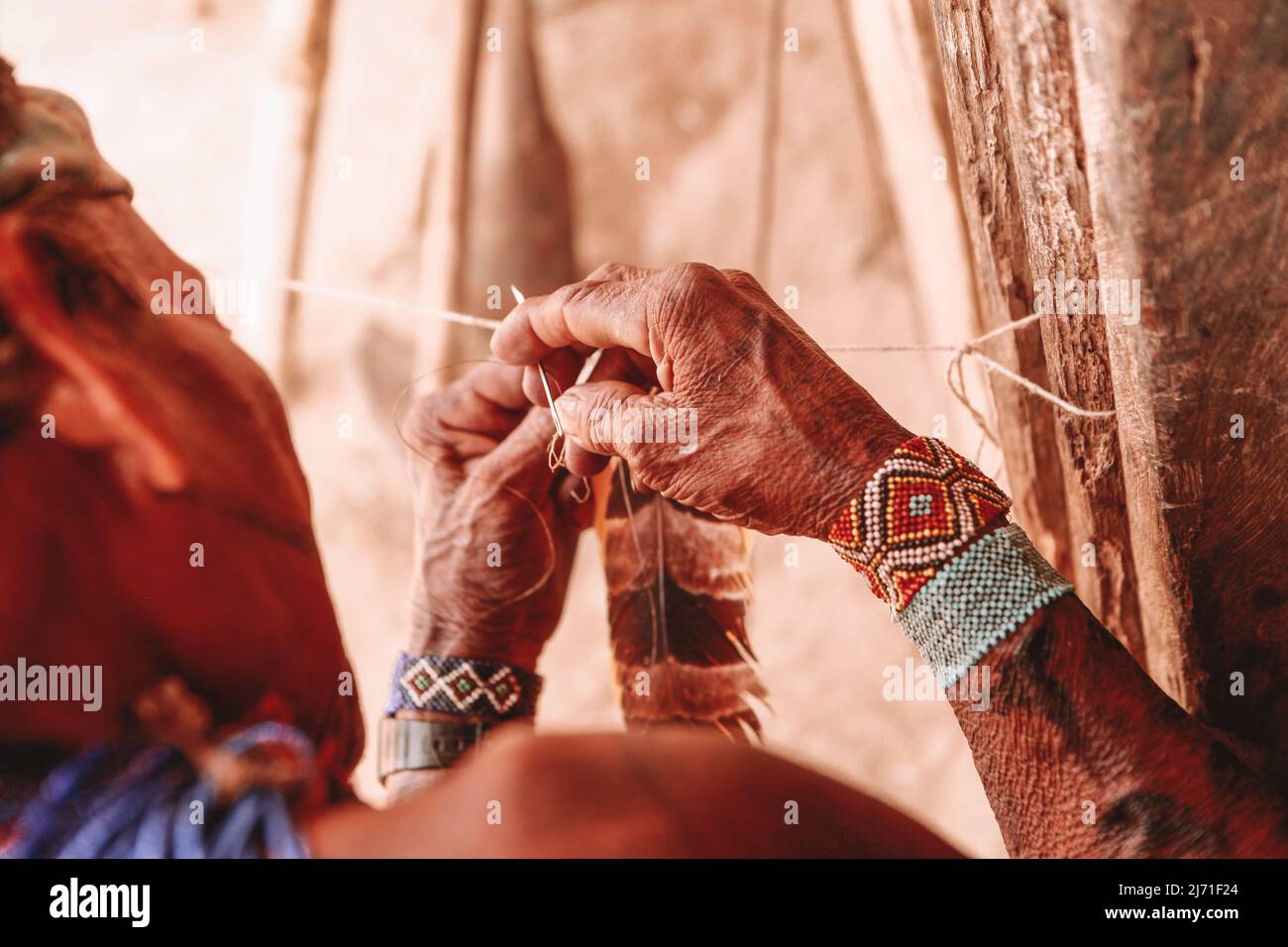 Ein indischer Mann, der einen Kokaberaufschmuck aus Federn basteln soll. Rio Xingu, September 2010. Stockfoto