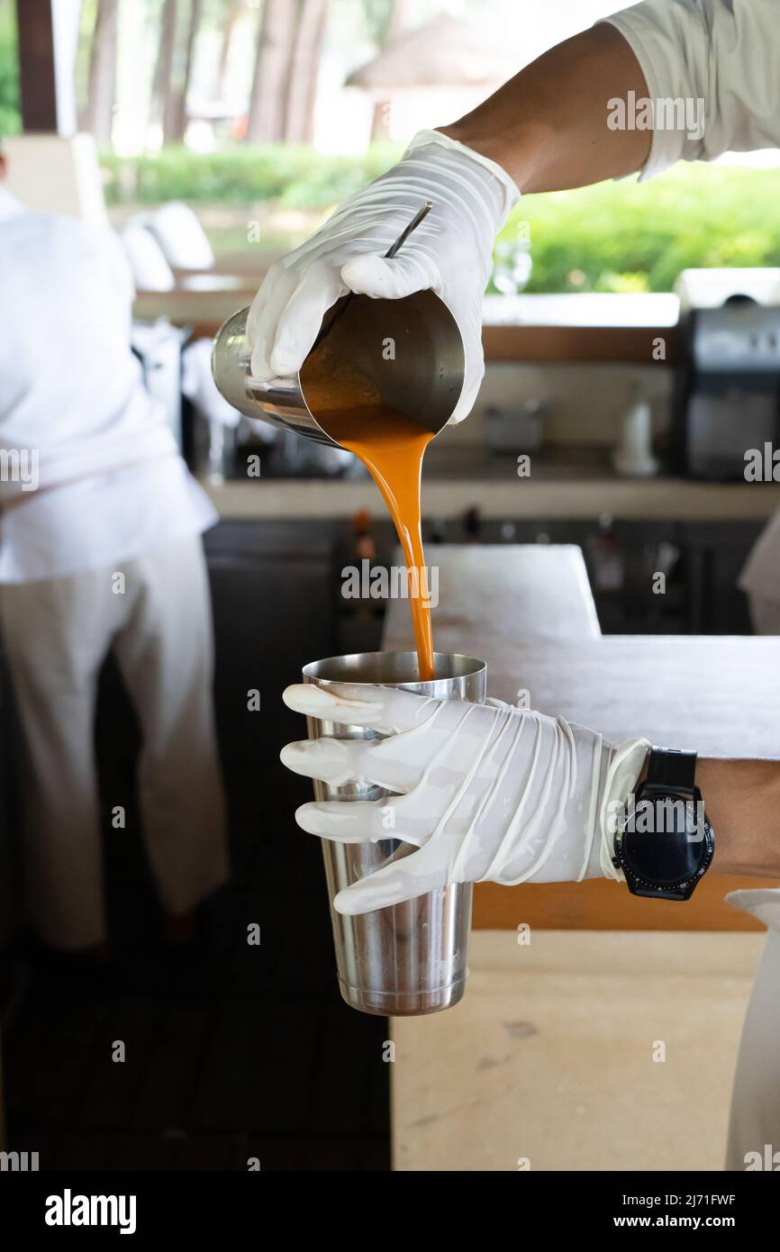 Ein Prozess der Herstellung von traditionellem Thai Eistee ist es, den Tee hin und her zu gießen. Der Grund dafür ist, die Temperatur anzupassen und die zu erstellen Stockfoto