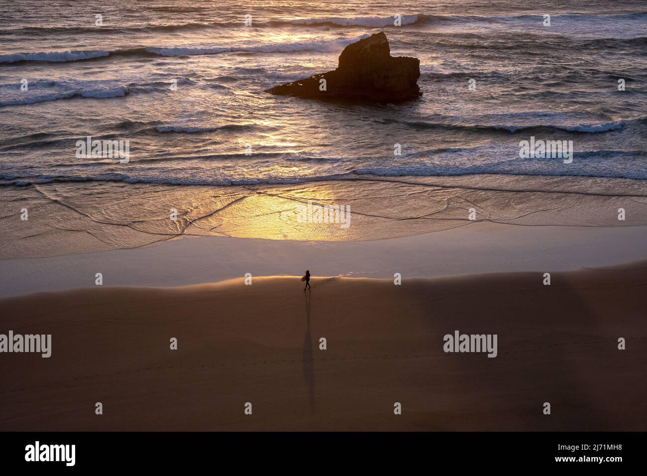 Surfer mit Surfbrett am Strand, Sagres, Portugal, Algarve-Küste, bei Sonnenuntergang, Wellen Stockfoto