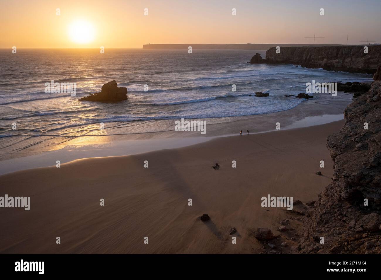Surfer mit Surfbrett am Strand, Sagres, Portugal, Algarve-Küste, bei Sonnenuntergang, Wellen Stockfoto