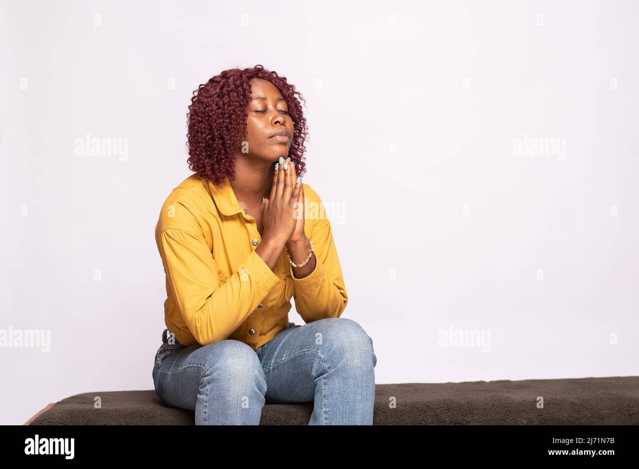 Junge afrikanische Dame spricht ihre Gebete Stockfoto