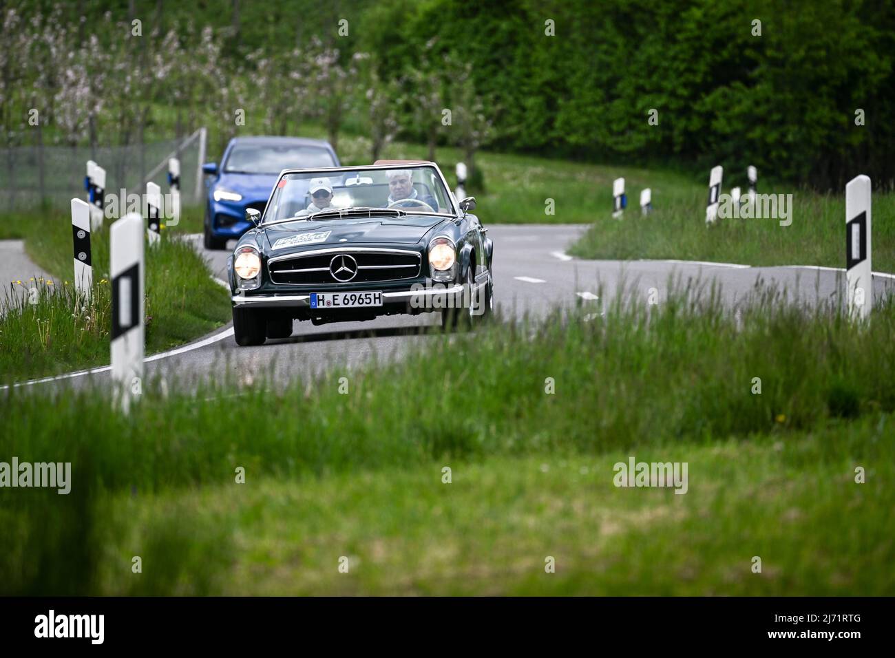 05. Mai 2022, Baden-Württemberg, Friedrichshafen am Bodensee: Paul Gabel fährt in der Mercedes-Benz 230 SL Pagode. Einen Tag vor dem Start der Motorworld Bodensee fahren mehr als hundert Oldtimer bei der Bodensee-Klassik 9., einer Oldtimer-Rallye, durch die ruhige Hügellandschaft rund um die Zeppelin-Stadt Friedrichshafen. Foto: Felix Kästle/dpa Stockfoto