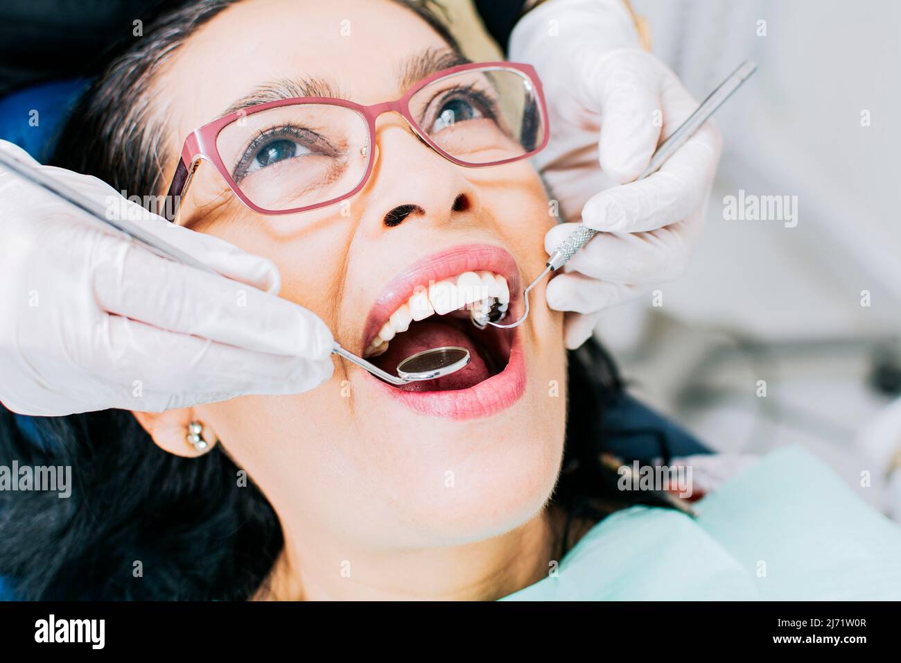 Patient vom Zahnarzt kontrolliert, Nahaufnahme des Zahnarztes mit Patient, Zahnarzt, der Wurzelbehandlung am Patienten durchführt, Zahnarzt, der zahnärztliche Untersuchung durchführt Stockfoto