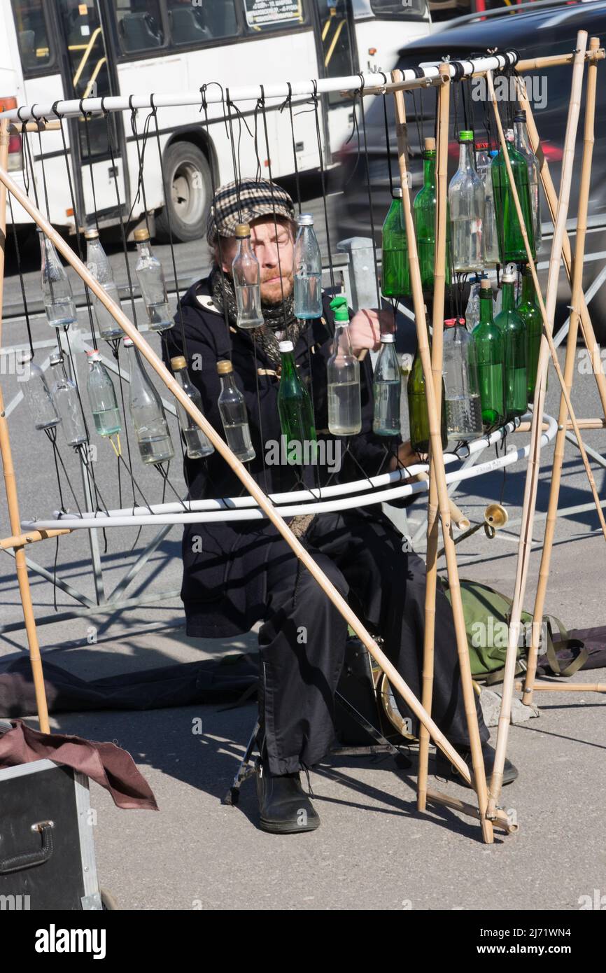 Ein Straßenmusiker spielt mit Inspiration auf Wasserflaschen. Bottle Percussion Musikinstrument Stockfoto