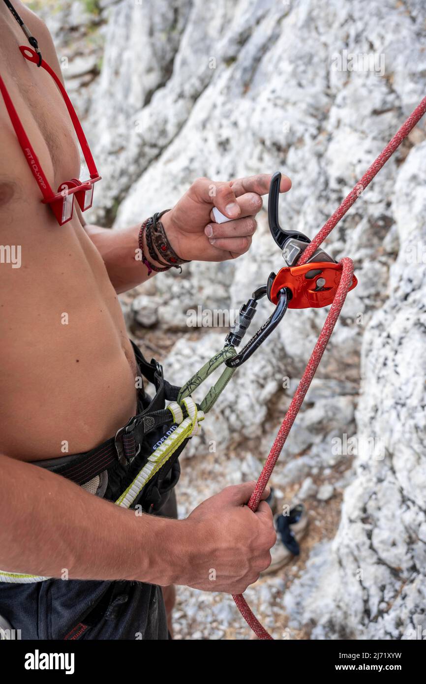Kletterer steht mit einem Grigori-Sicherungsgerät, Sportklettern, Kalymnos, Dodekanes, Griechenland Stockfoto