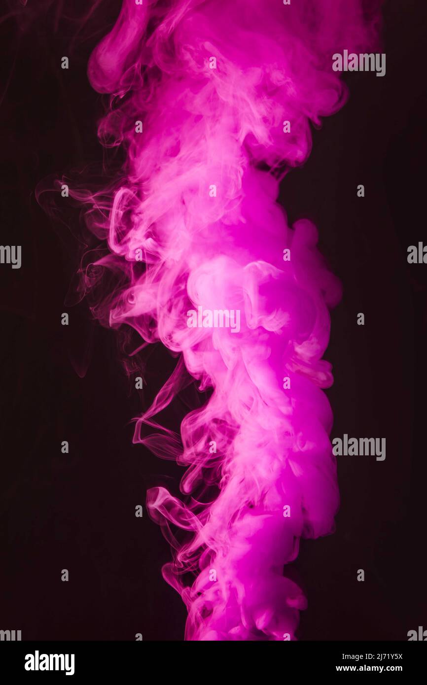 Abstrakte dichte flauschige Puffs von rosa Rauch auf schwarzem Hintergrund Stockfoto