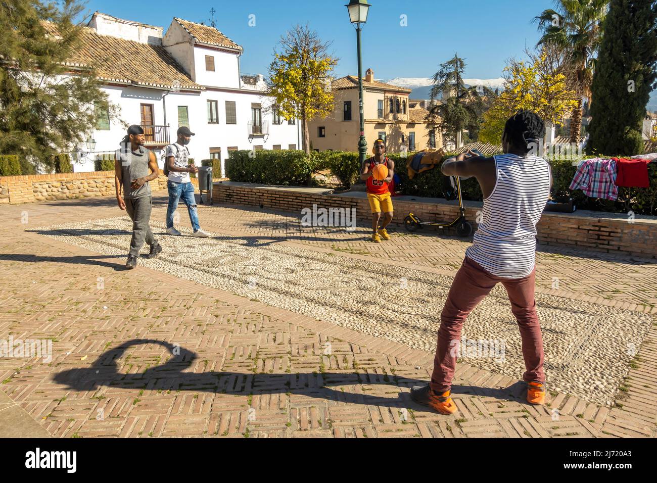 Vier schwarze junge Männer spielen Basketball an einem spontanen Ort im historischen Zentrum von Granada am C San Ncolas, Andalusien, Spanien Stockfoto