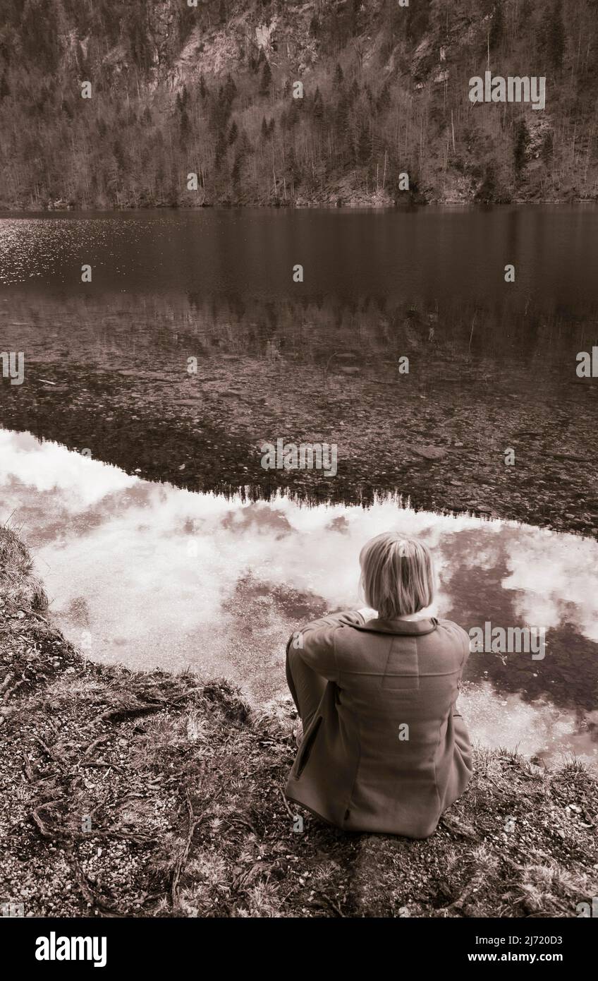 Sepiafarben, Frau sitzt am Ufer des Toplitzsee, Salzkammergut, Steiermark, Oesterreich Stockfoto