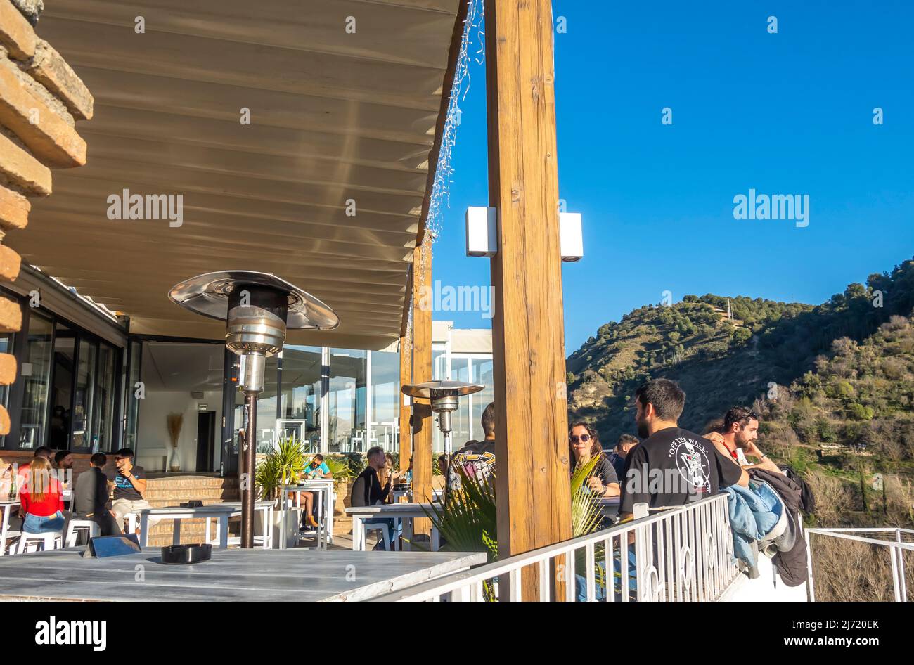 Terrasse im Freien in Albaizin Granada Café mit Touristen, post-covid Reisen und Essen an historischer Stelle, Wahrzeichen in Andalusien, Spanien Stockfoto
