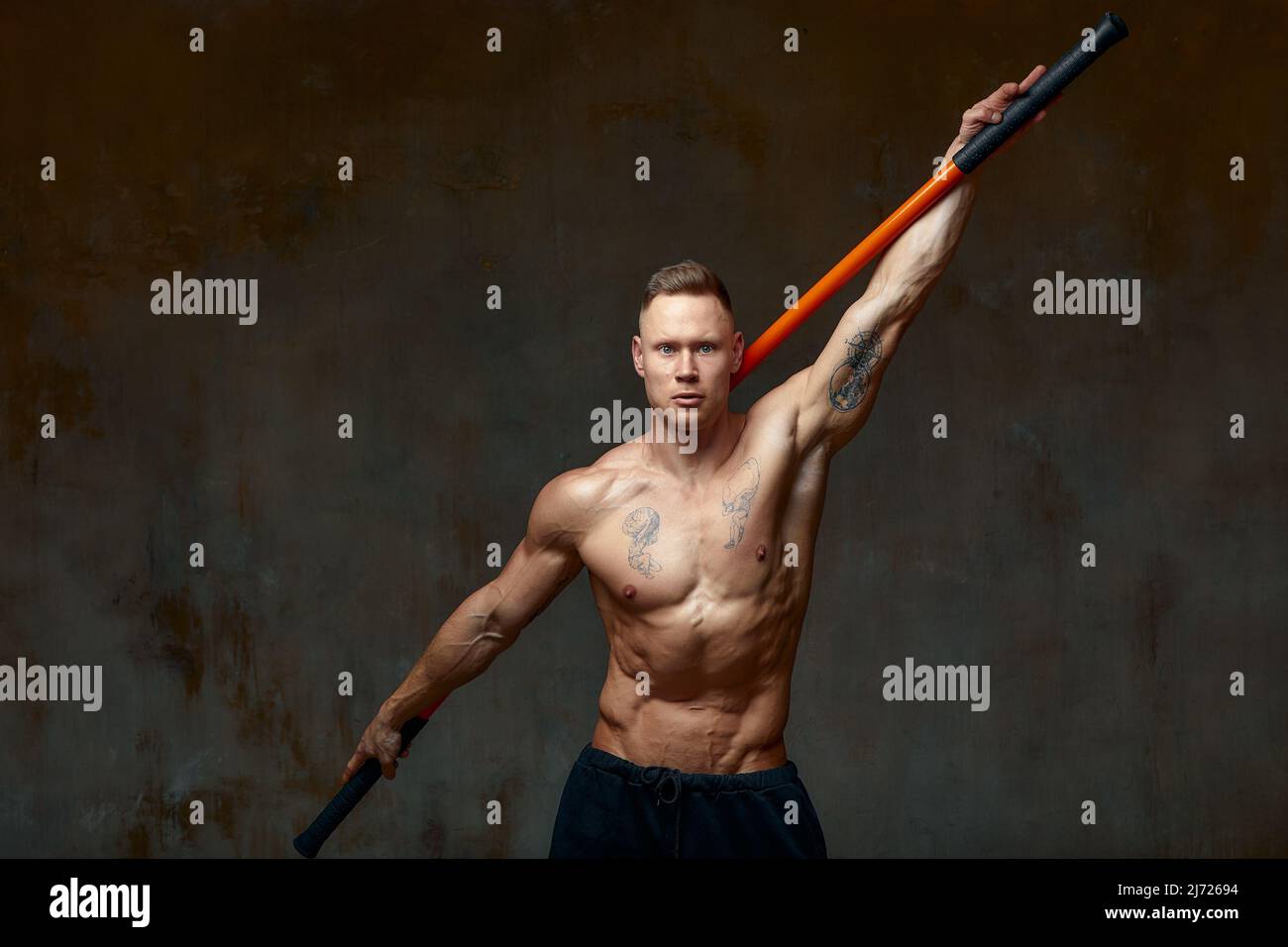 Sportler Männer mit Stick Training Karate mit Sport-Tool im Studio auf grauem Licht Hintergrund Stockfoto