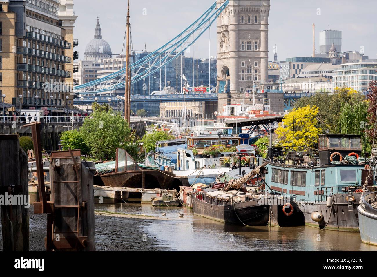 Mit dem Finanzviertel der Hauptstadt im Hintergrund werden am 5.. Mai 2022 in London, England, Lastkähne und Feuerzeuge an der Tower Bridge Moorings an der Themse zusammengefasst. Tower Bridge Moorings ist der einzige schwimmende Garten der Hauptstadt - eine nachhaltige Lebensweise für eine Gemeinschaft von mehr als hundert Erwachsenen und Kindern und ein Schutz für Wildtiere auf dem Fluss. Tower Bridge Moorings ist der einzige schwimmende Garten der Hauptstadt - eine nachhaltige Lebensweise für eine Gemeinschaft von mehr als hundert Erwachsenen und Kindern und ein Schutz für Wildtiere auf dem Fluss. Stockfoto