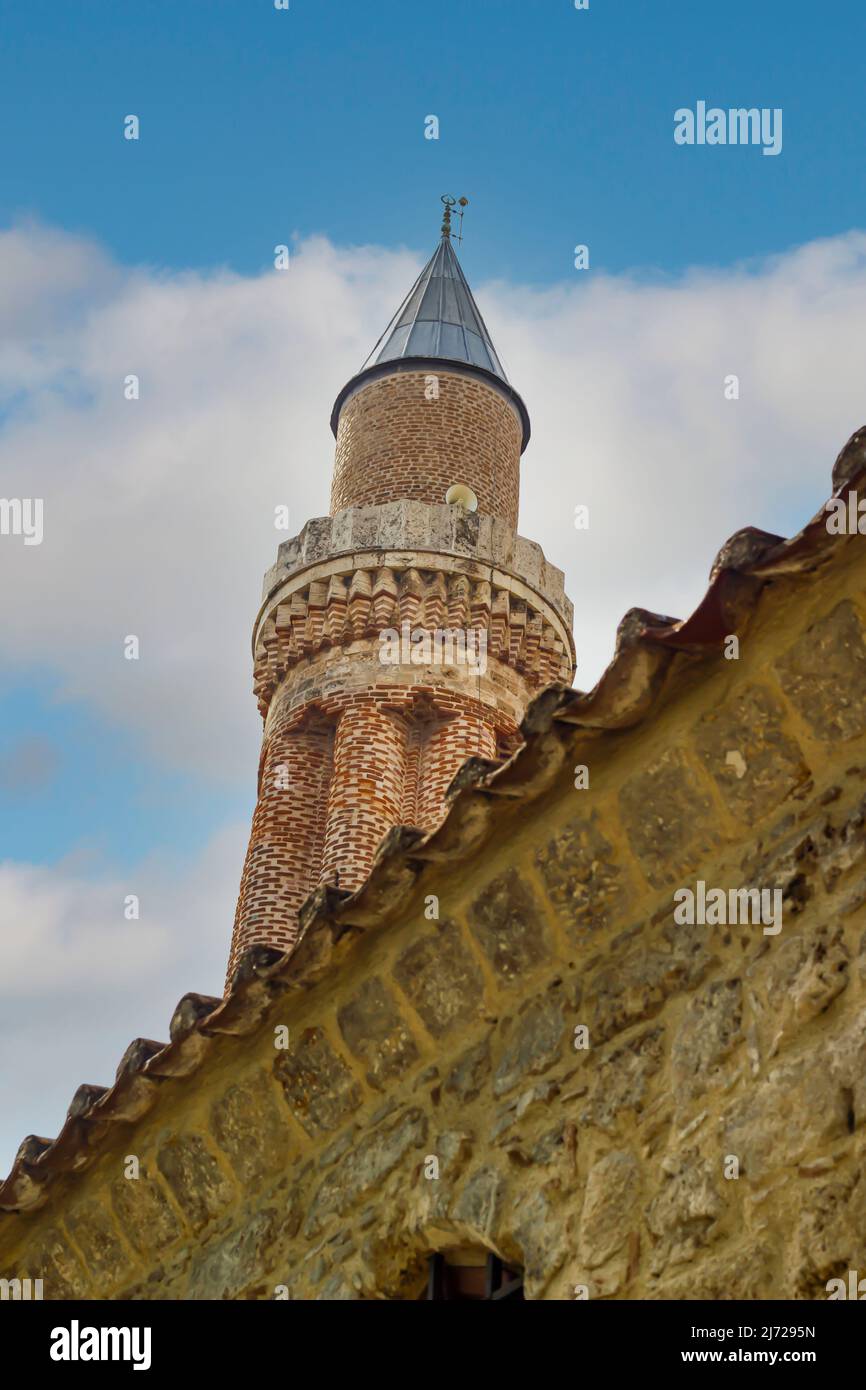 Altes Minarett einer islamischen Moschee hinter Mauern mit blauem Himmel oder weißen Wolken Landschaft, kreative Ansicht Stadt Foto Konzept Idee. Stockfoto