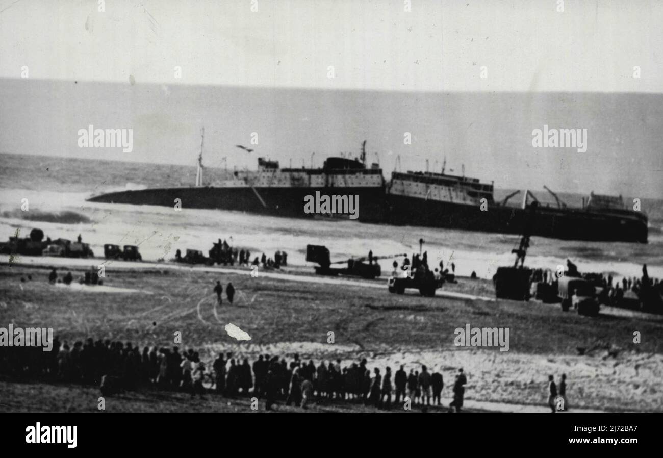 Doomed Liner -- Dieses neue Bild des zum Scheitern verurteilten französischen Liner Champollion, das heute in London am 24.. Dezember aufgenommen wurde, zeigt, wie viele an der libanesischen Küste versammelten Personen Rettungsversuche am 23.. Dezember beobachten. Der 12.546 Tonnen schwere Liner, der zu Weihnachten Pilger ins Heilige Land trug, brach am 22.. Dezember auf einer Sandbank 300 Meter vor der libanesischen Küste in zwei Teile ein. Nachdem alle anderen Rettungsversuche gescheitert waren, unternahm Kapitän Baltaji, Hauptpilot in Beirut, mit seinem Motorboot eine wagemutige Reise durch schwere Meere zum Wrack und brachte 50 Menschen an Land. 24. Dezember 1952. (Foto von Associated Press Pho Stockfoto