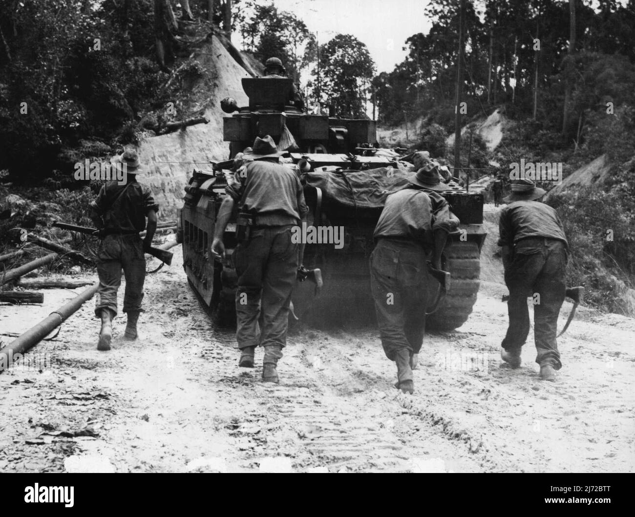 Ingenieure des 2/48. Australischen Infanterie-Bataillons, das hinter dem Matilda-Panzer der C-Staffel hockt, 2/9. das Australische Panzerregiment, das nach Sykes aufmarschiert, um bereits eingetropfte Truppen zu unterstützen, aber aufgrund von Verletzten geschwächt wurde. 06.Mai 1945. (Foto: Australian war Memorial Canberra, A.C.T.). Stockfoto