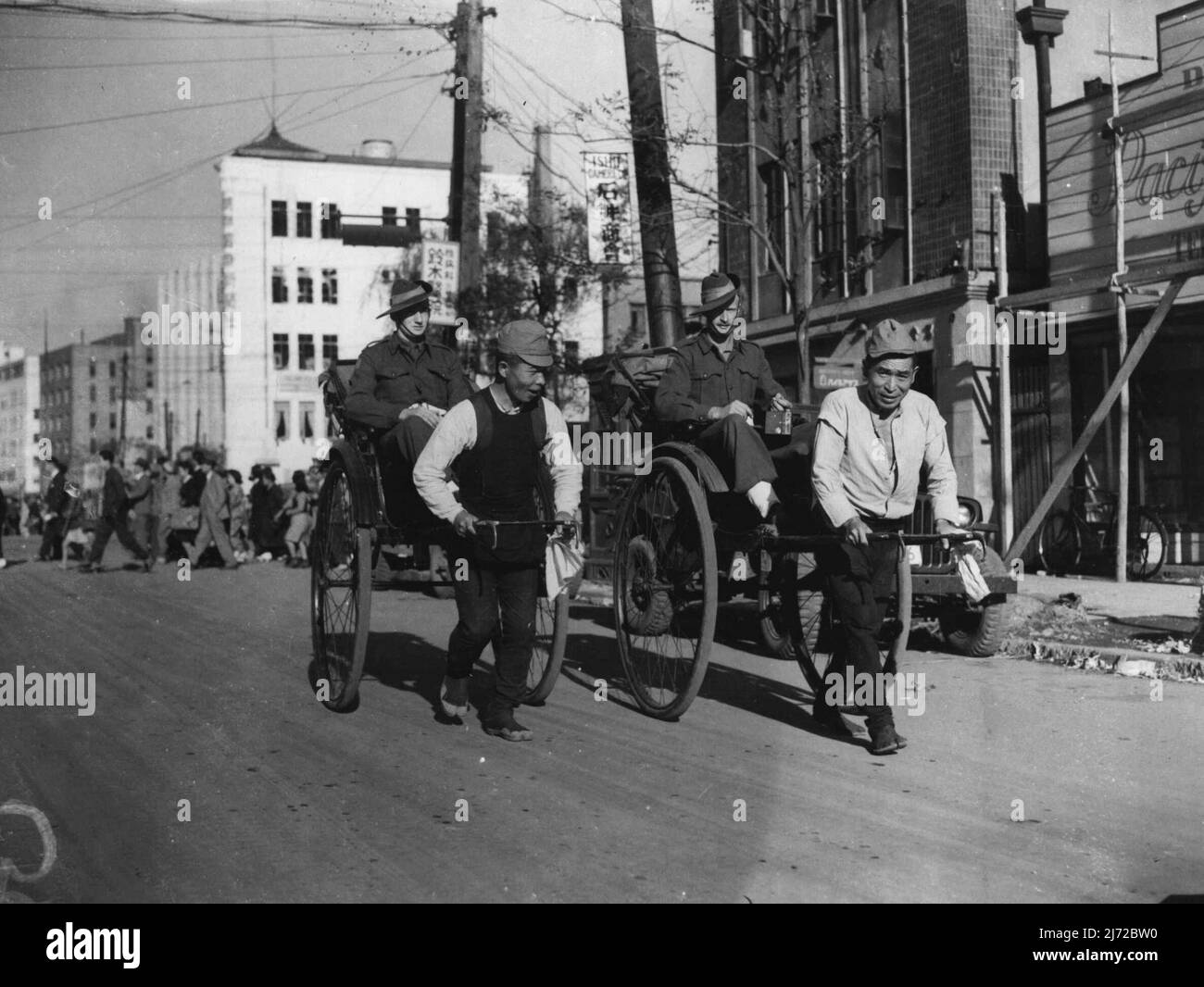 Australische Digger in Japan haben die Situation offenbar gut in der Hand, wie dieses Bild zeigt, wie sie in von Japanern gezogenen Rikschas reiten. Die Diggers waren auf einer Besichtigungstour durch Tokio. 13. November 1946. Stockfoto