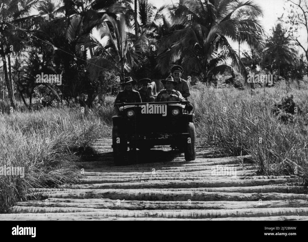 Ein Jeep verhandelt eine „Cord“-Straße über einen Sumpf. Der einzige erfolgreiche Weg, eine Straße in dieser Art von Land zu bauen. Die Straße wird durch das Platzieren von Kokosnussstämmen über den Sumpf gemacht, und brauchen ständige Aufmerksamkeit. 11.Mai 1944. Stockfoto