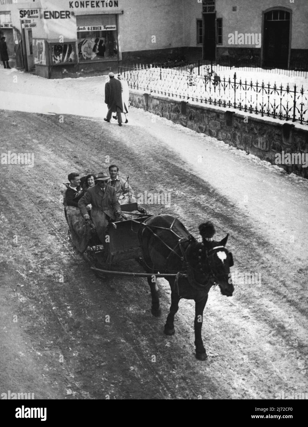 Schlittenfahrt durch St. Moritz -- RAF-Männer und ihre Frauen genießen den ungewöhnlichen Nervenkitzel einer 8-Meilen/Stunde-Schlittenfahrt durch die Straßen des berühmten Schweizer Wintersportzentrums. 24. Juli 1949. (Foto von Kamera Drücken Sie). Stockfoto