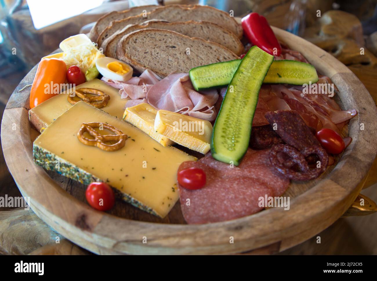 Typisch europäischer Imbiss mit Wurst, Käse und Brot. Appetitlich zubereitet auf einem rustikalen Brett. Stockfoto