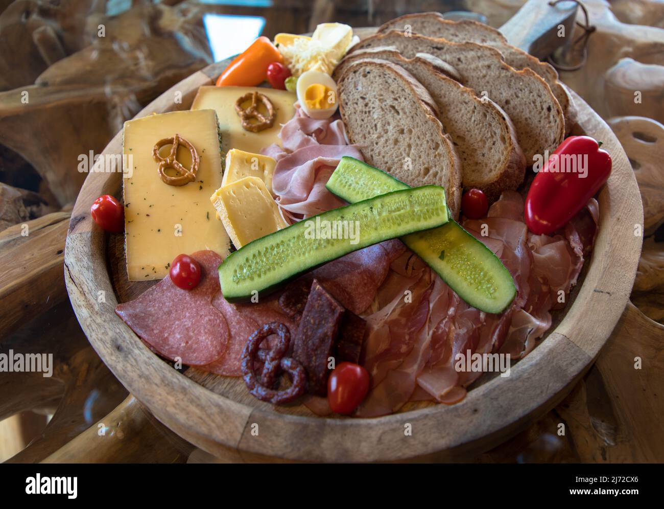 Typisch europäischer Imbiss mit Wurst, Käse und Brot. Appetitlich zubereitet auf einem rustikalen Brett. Stockfoto