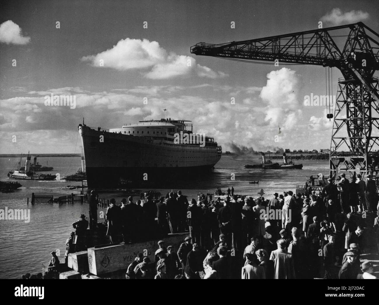 Größter Liner der Nachkriegszeit gestartet -- der 31.000-Tonnen-Liner 'Orcades', der von Vickers-Armstrong für die Orient Line auf ihren Barrow-in-Furness Yards gebaut wurde, wurde gestern von Lady Morshead, Frau des Sydney Manager of the Line, gestartet. Die 'Orcades' ist das größte Handelsschiff der Welt, das seit dem Krieg gestartet wurde und für den australischen Handel zu einem Preis von £3.000.000 gebaut wurde. Es wird über 1.500 Passagiere und 608 Besatzungsmitglieder befördern. Das Bild zeigt Schlepper, die sich um das Schiff schuften, um sie nach dem Start in die Ausrüst-Werften zu bringen. 15. Oktober 1947. Stockfoto