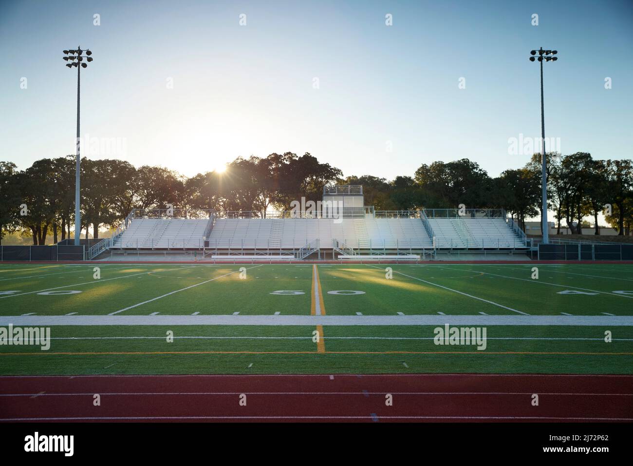 Blick auf das Spielfeld auf eine High School-Rennstrecke und ein Fußballfeld in Texas bei Sonnenaufgang Stockfoto