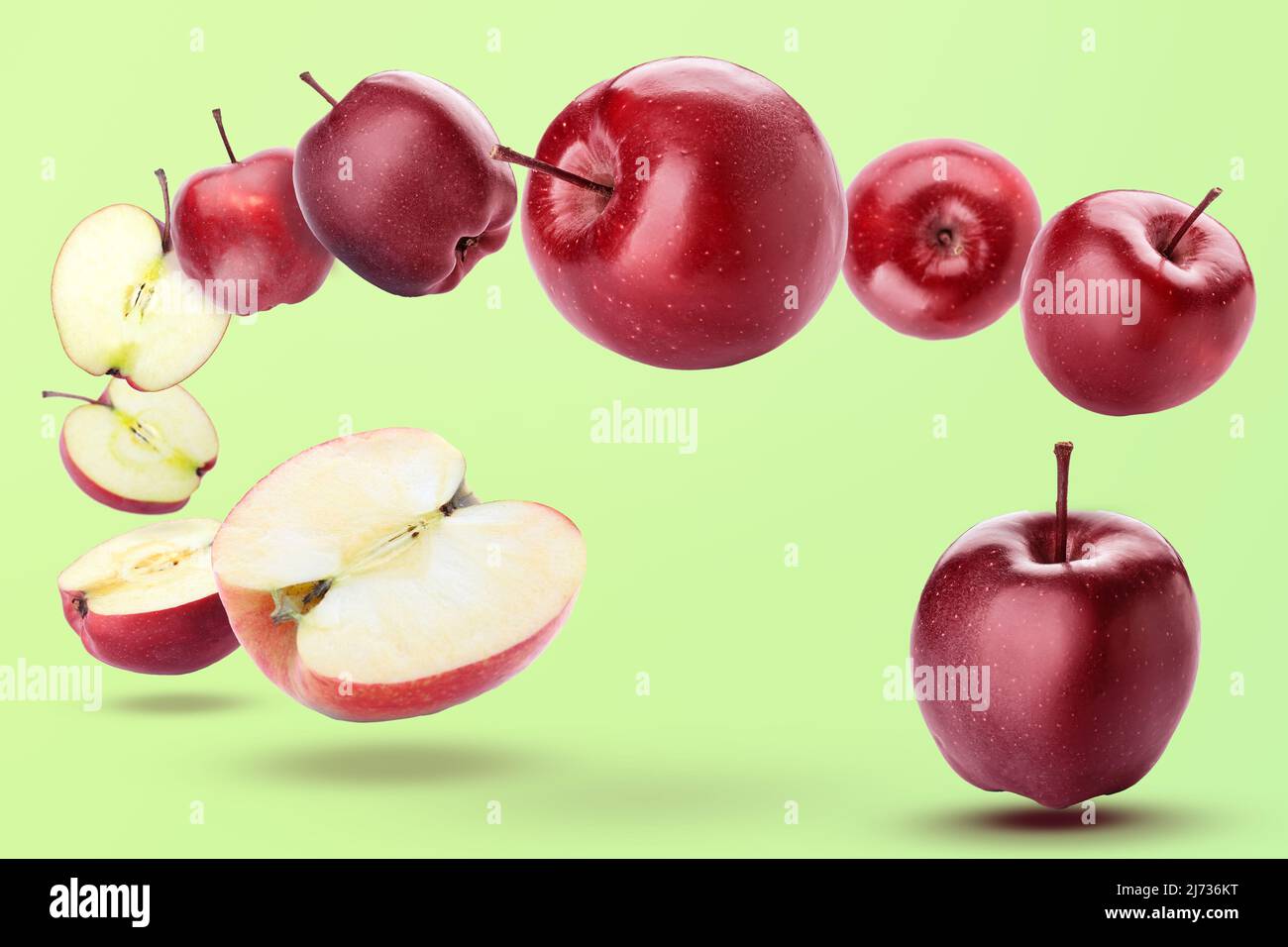 Reife rote fliegende Äpfel und Hälften auf grünem Hintergrund Stockfoto