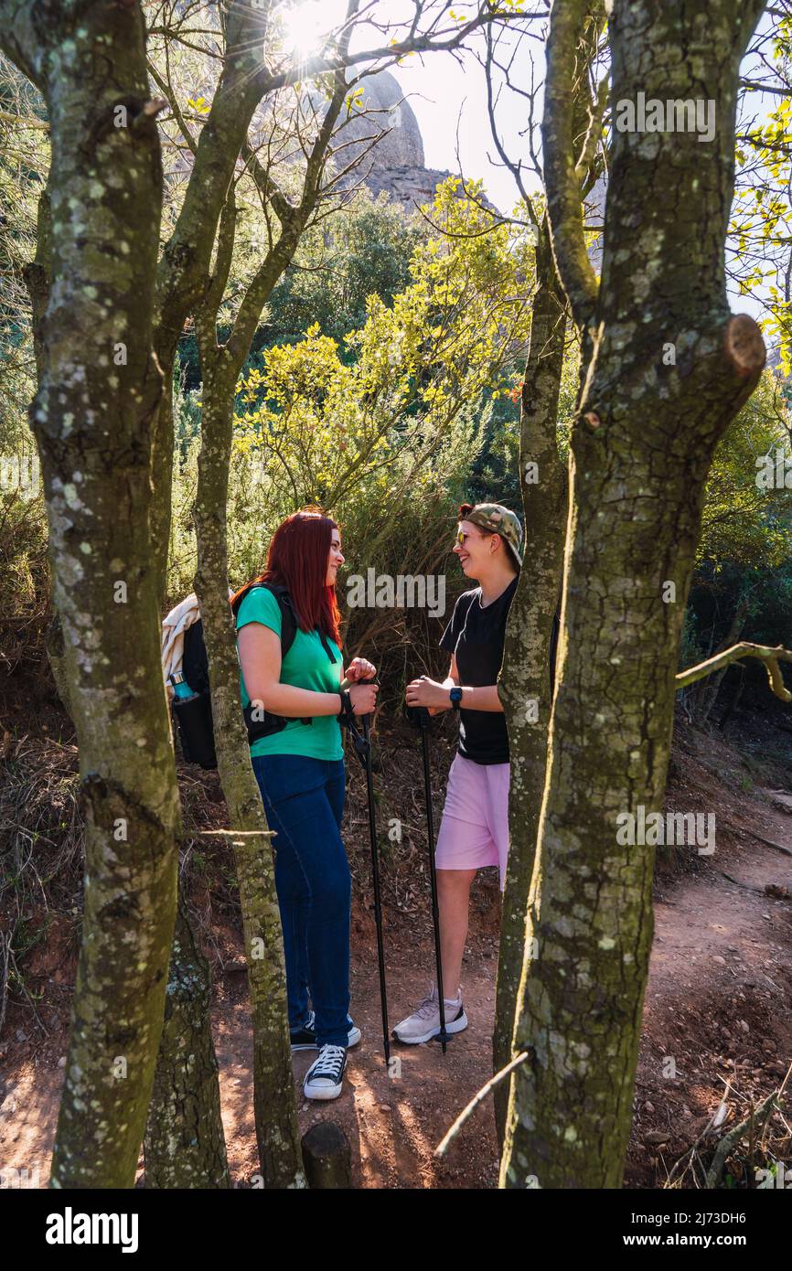 Zwei Freundinnen genießen eine Wanderung in der Natur. Junge Menschen im Urlaub. Frauen stehen auf einem Bergpfad. Stockfoto