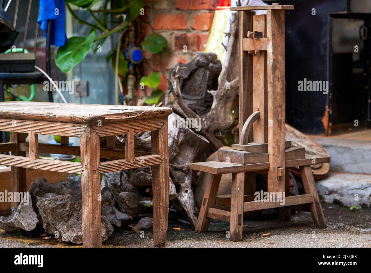 Holzmöbel und landwirtschaftliche Geräte auf dem Land Stockfoto