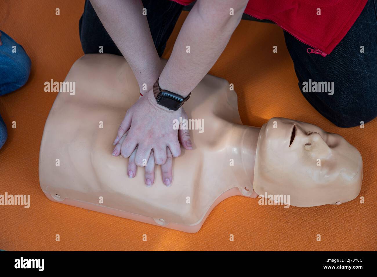 Frau, die CPR an einer Schaufensterpuppe zum Training durchführt. Direkte Herzmassage. Erste-Hilfe-Training auf einem medizinischen Dummy. Herzmassage bei Herzstillstand Stockfoto