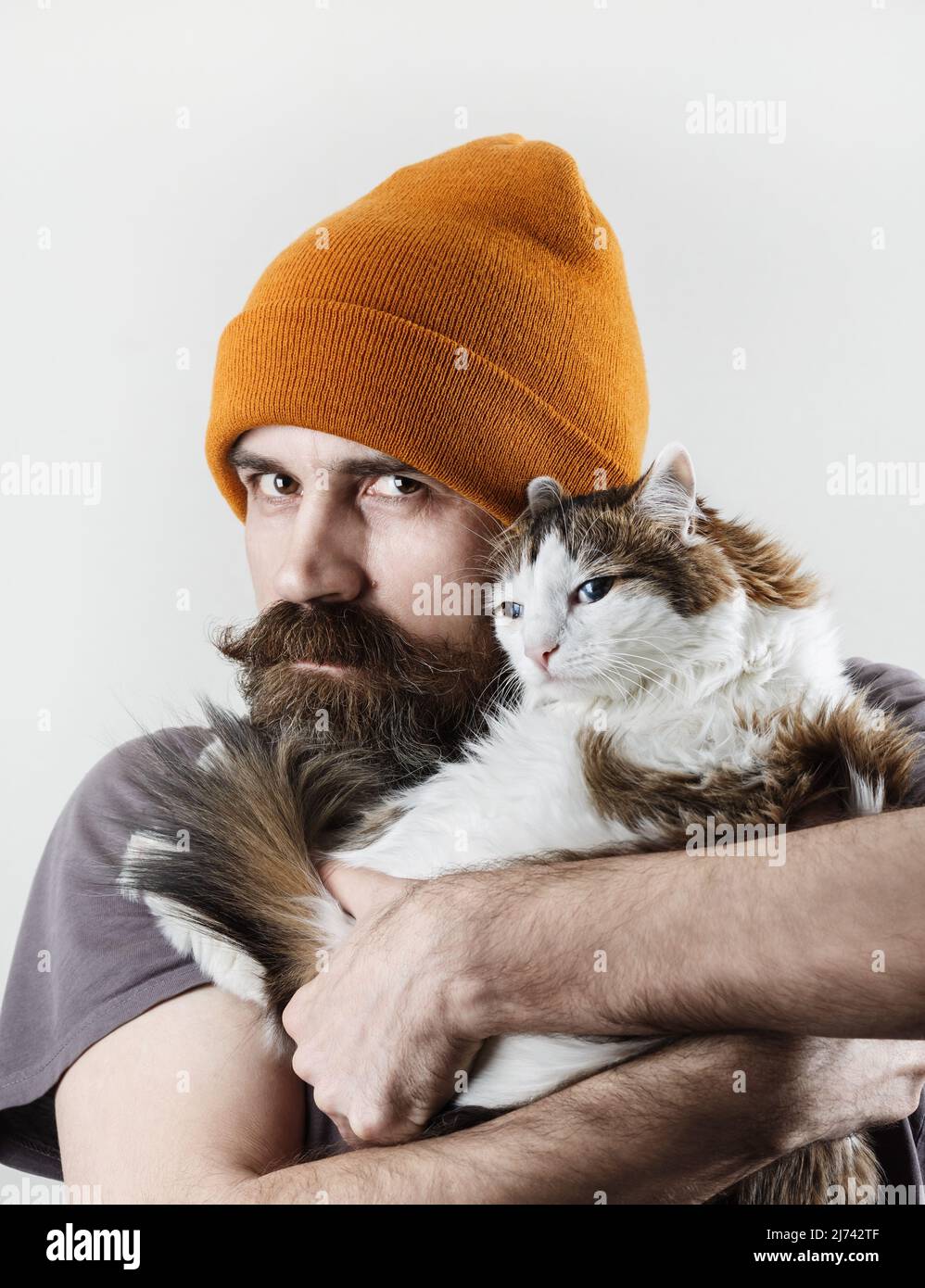 Hipster und Katze. Bärtiger Mann mit seiner geliebten Katze. Stockfoto