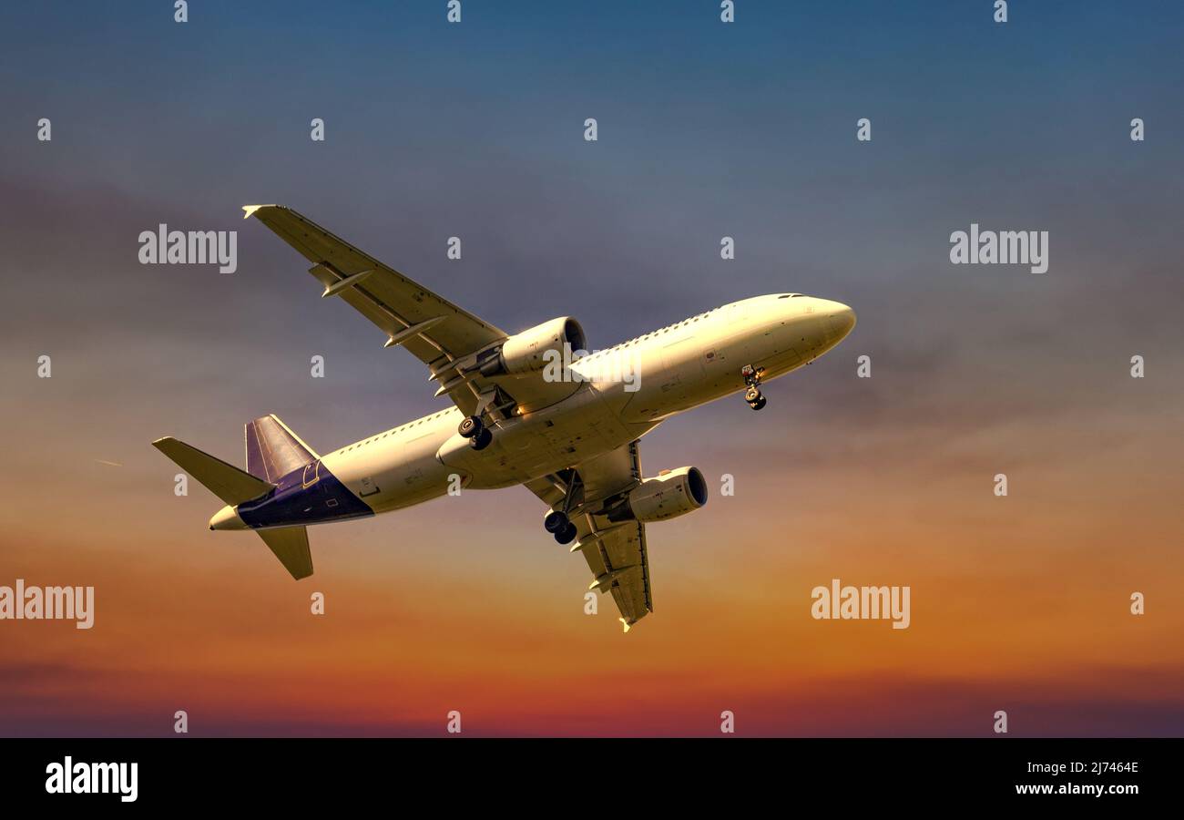 Passagierflugzeuge, die im Abendlicht unter den Wolken fliegen. Stockfoto