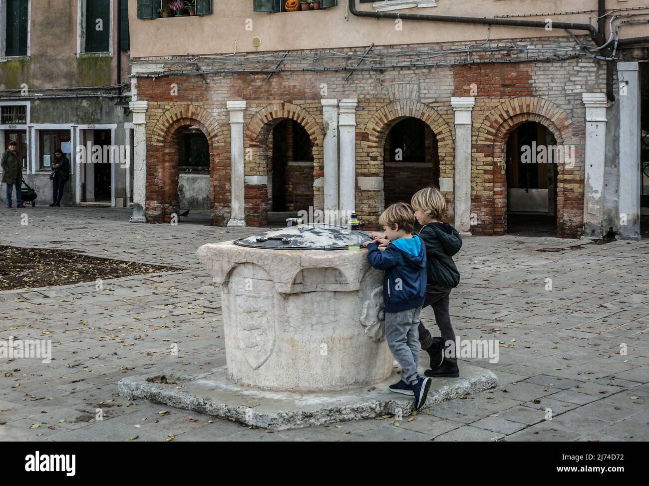 Italien Venedig Campo de Ghetto Novo -558 östliche Platzfront Nutzungsbeginn 1516 Knaben an einer Zisterne Stockfoto