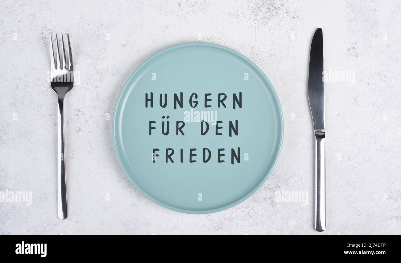 Hunger nach Frieden steht in deutscher Sprache auf dem leeren Teller, Lebensmittelknappheit durch den Krieg in der Ukraine, politische Frage Stockfoto Hunger nach Frieden steht in deutscher Sprache auf dem leeren Teller, Lebensmittelknappheit durch den Krieg in der Ukraine, politische Frage Stockfoto