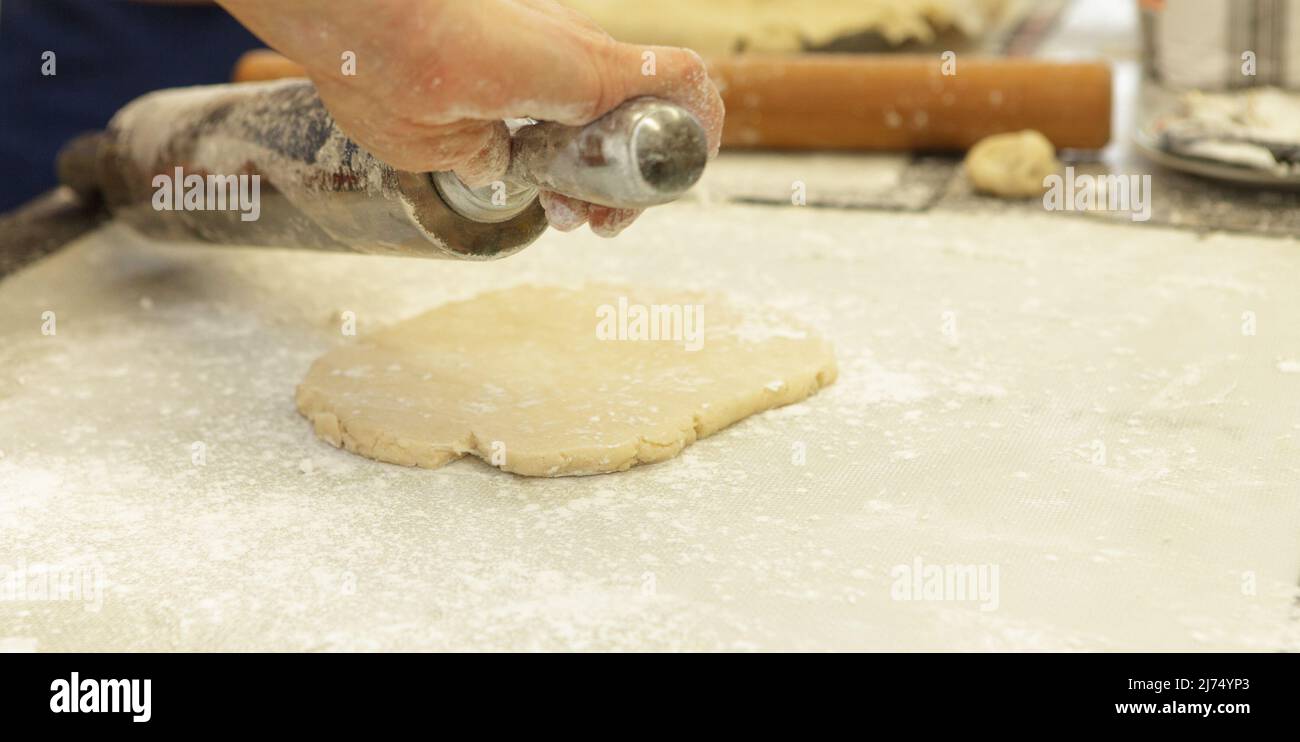 Vorbereitung Apple Pies in einem großen kommerziellen Küche für die Feiertage mit hausgemachten Kuchen Kruste - Teil einer Serie Stockfoto