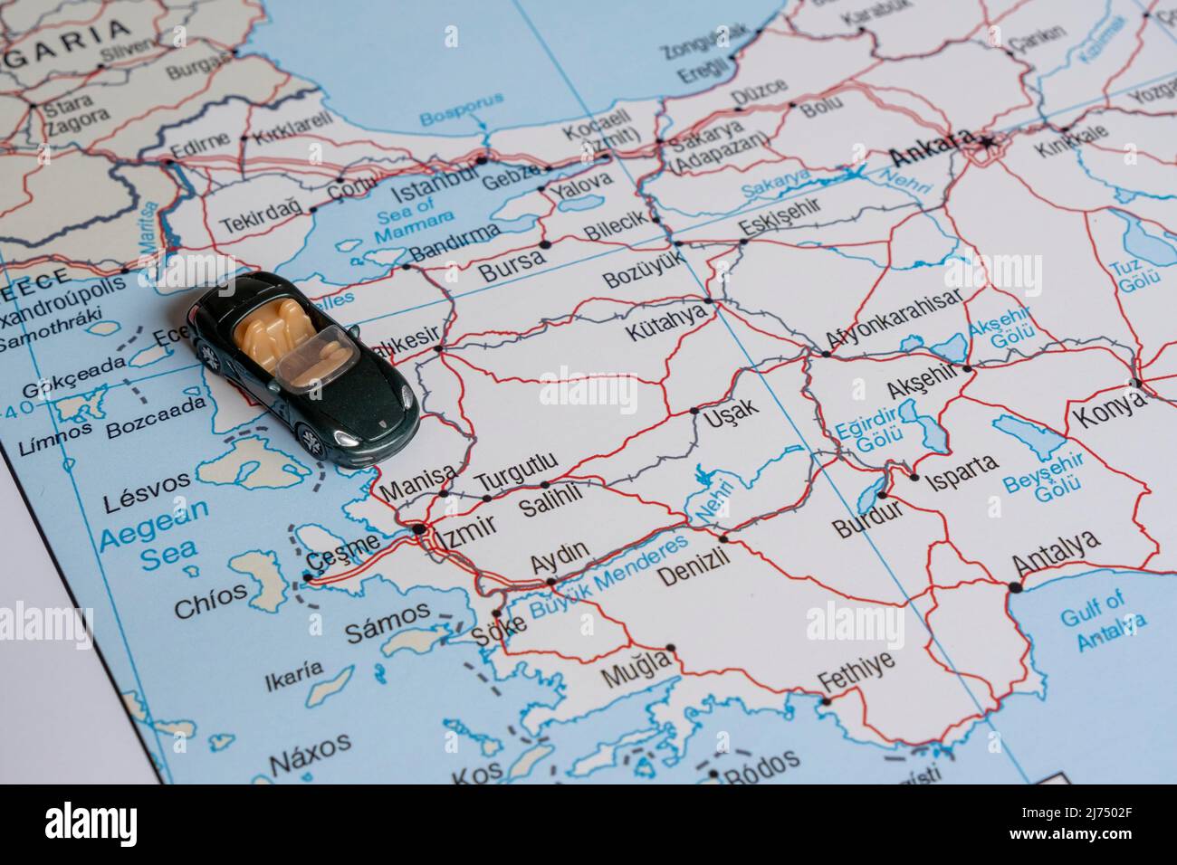 Spielzeugauto auf Türkei-Karte, grüner Miniatursportwagen auf der Ägäis-Region, Seitenansicht, Türkei-Reisekonzept, Kartenidee, Landtour Stockfoto