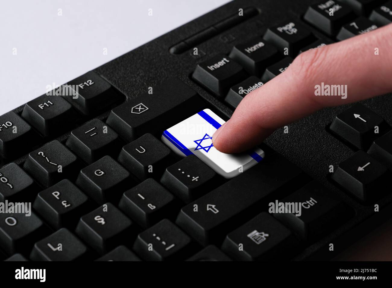 Das Drücken der Enter-Taste mit der israelischen Flagge stellt einen Cyber-Angriff Israels dar, eine Metapher für das Erlernen der hebräischen Sprache, eine schwarze Tastatur aus nächster Nähe Stockfoto