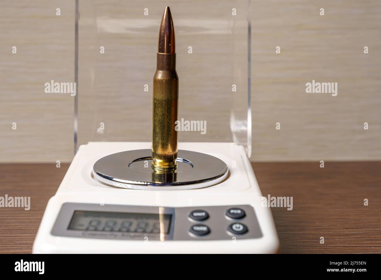 Großkalibrige Patrone für ein Gewehr auf der Schale mit elektronischen Waagen, Nahaufnahme. Stockfoto